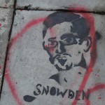 A stenciled head of Edward Snowdensprayeed on pavement